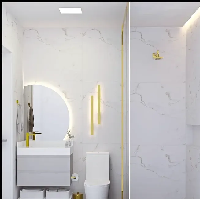 Banheiro em mármore branco com espelho iluminado e detalhes dourados